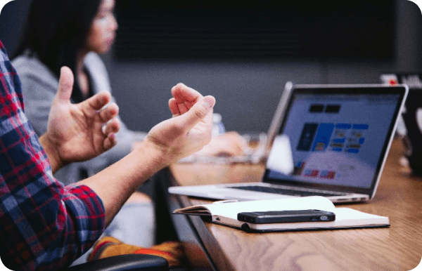 A man drawing gesturing at a laptop